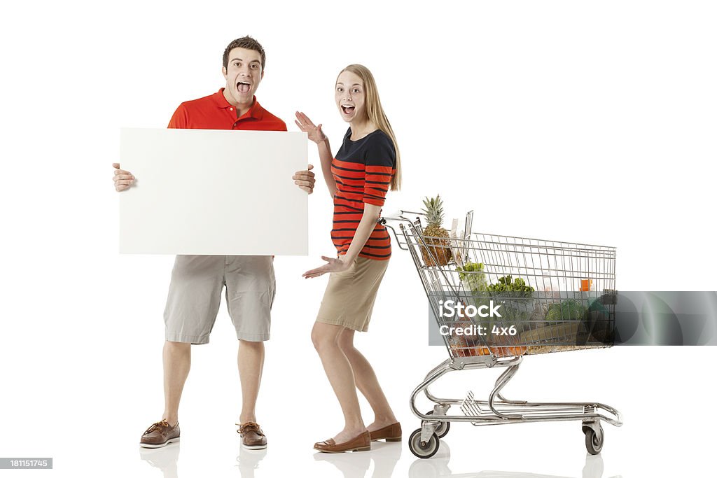 Heureux couple avec une pancarte dans le supermarché - Photo de Adulte libre de droits