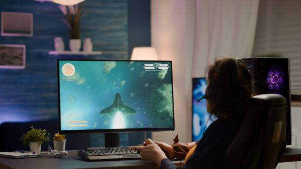 istock Back shot of pro gamer playing online space shooter game on powerful computer 1811518201