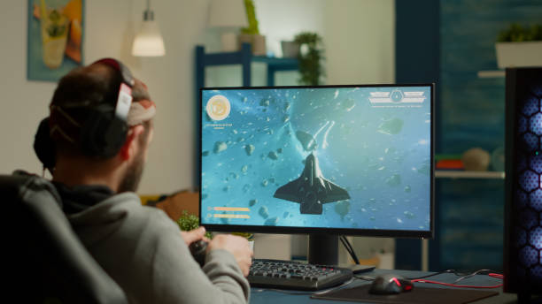 istock Pro man gamer playing video game at powerful personal computer late night 1811522626