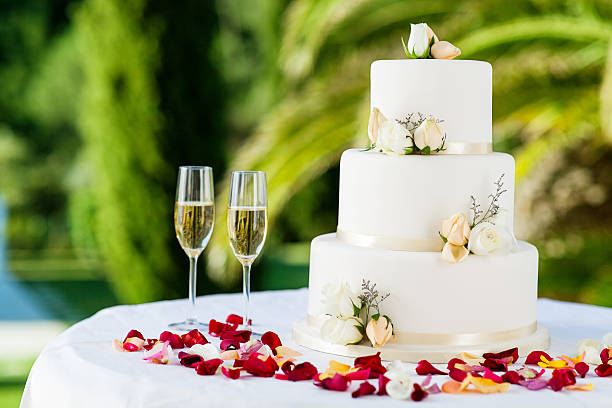 Wedding Cake With Champagne Flutes On Table Wedding cake with champagne flutes on table at reception in garden. Horizontal shot. wedding cake stock pictures, royalty-free photos & images
