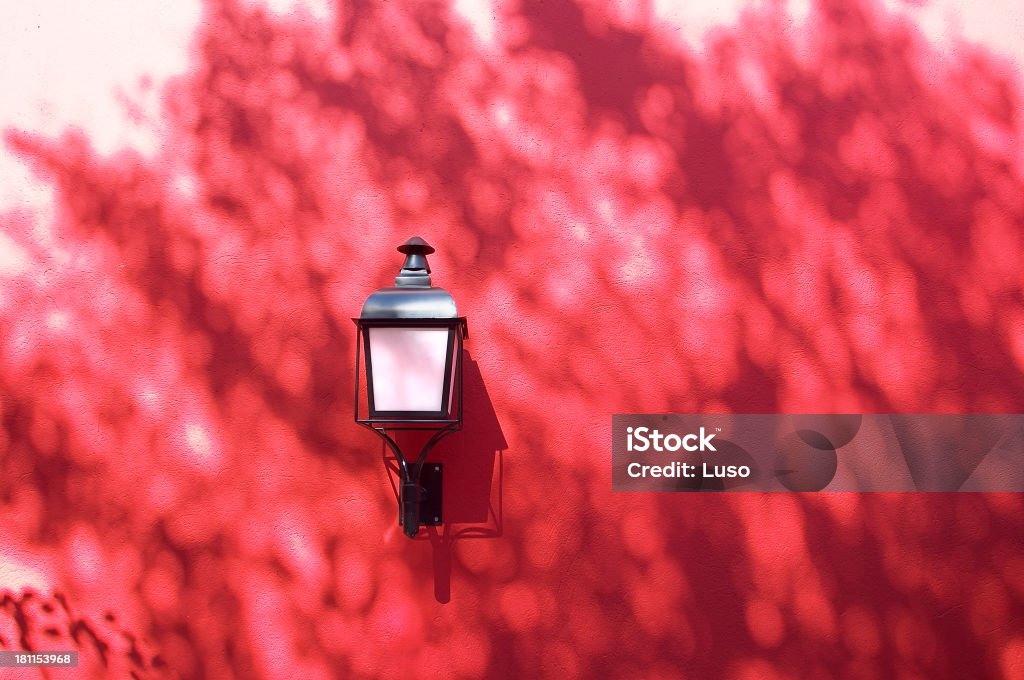 Muro rosso, lampada & ombre - Foto stock royalty-free di Aiuola