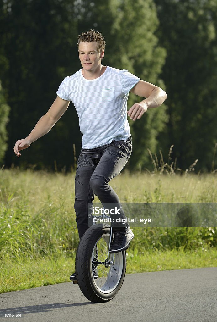 young unicyclist young artist riding on an unicycle. Taken in morning time with some backlite. Unicycle Stock Photo
