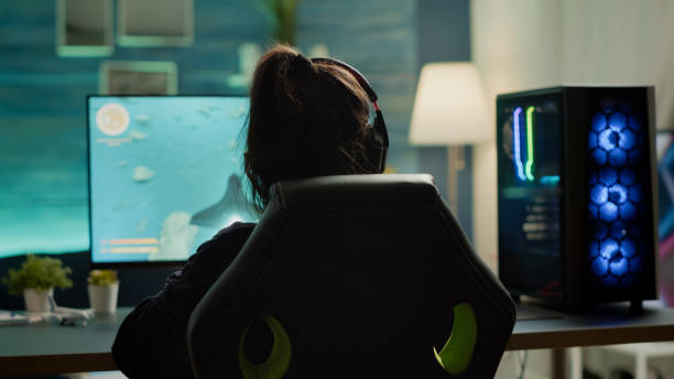 istock Back view of digital pro player playing online space shooter video game 1811548842