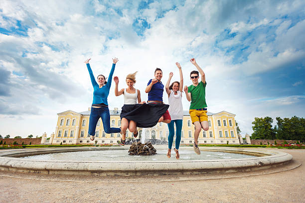 gruppo di amici salti - arms raised green jumping hand raised foto e immagini stock