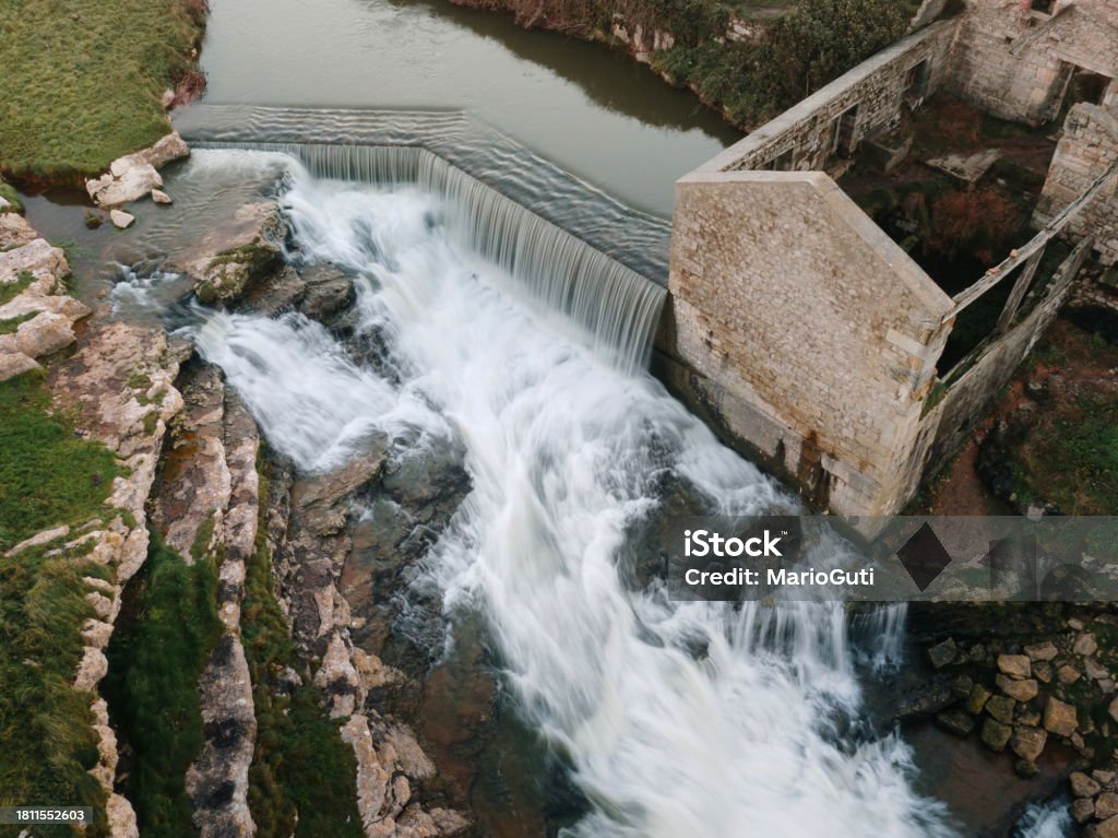 Abandoned mill with waterfall as seen from above Aerial view of an abandoned mill with a waterfall. El Bolao in Cobreces, Cantabria, Spain. Abandoned Stock Photo
