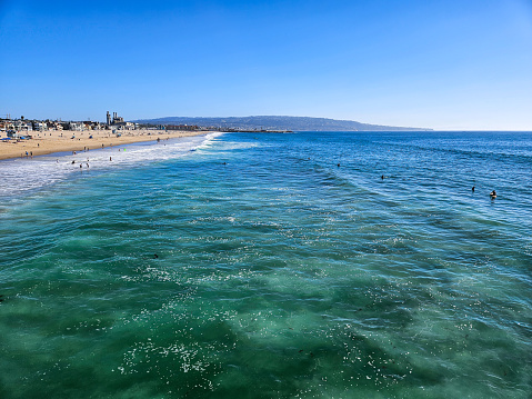 The vibrant coast of Hermosa Beach, California. Some surfers enjoying the ocean.