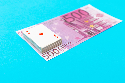 500 Euro With One Note and small toy playing cards lie on banknote blue background