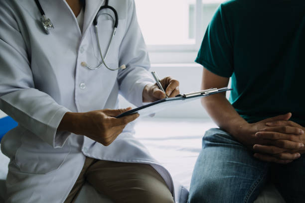 Male patient having consultation with doctor or psychiatrist who working on diagnostic examination on men's health disease or mental illness in medical clinic or hospital mental health service center Male patient having consultation with doctor or psychiatrist who working on diagnostic examination on men's health disease or mental illness in medical clinic or hospital mental health service center cancer screening stock pictures, royalty-free photos & images