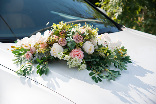 Wedding car decorated with flowers on the door.
