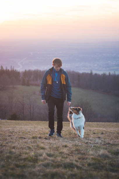 istock Young cynologist, a dog trainer trains a four-legged pet Australian Shepherd in basic commands using treats. Love between dog and human 1811586888