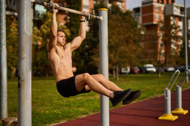männlicher athlet trainiert am reck im freien - body building men flexing muscles male stock-fotos und bilder