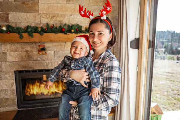 Mother and her baby boy for Christmas at home in living room arranging Christmas decoration