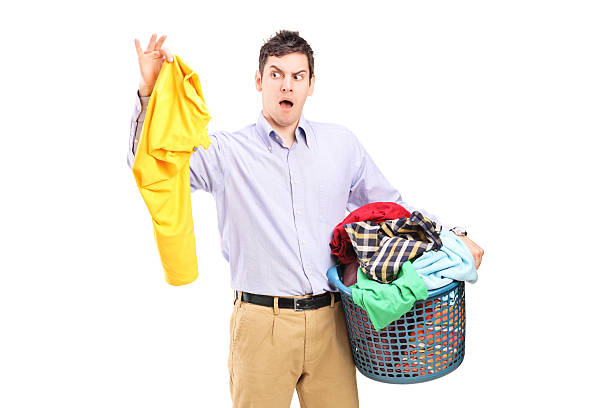 istock Man holding a smelly blouse and laundry basket 181162094
