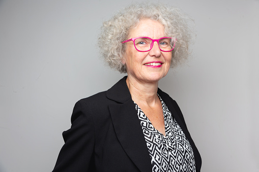 senior businesswoman wearing pink eyeglasses