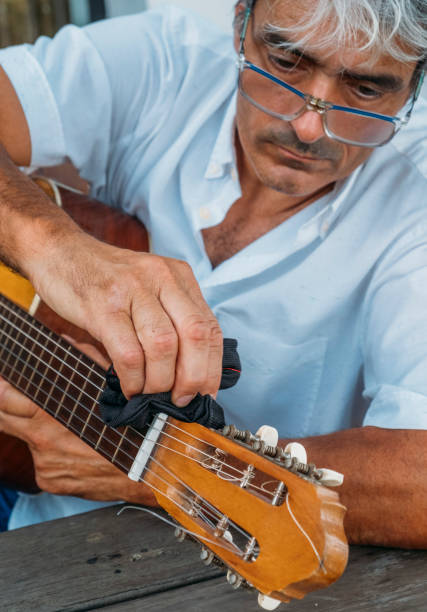 istock Attractive white hair man cleaning a guitar. 1811640749