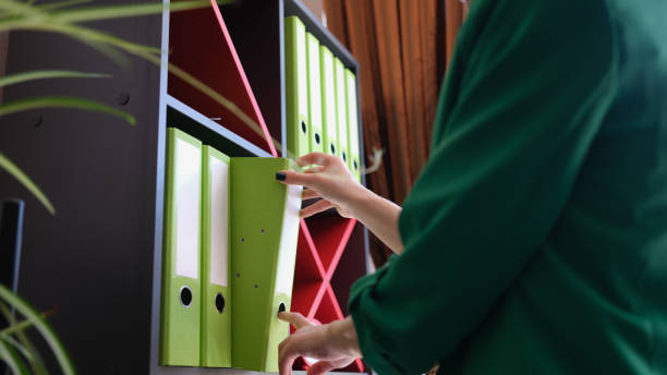 istock Green folders in office woman takes folder with documents from cabinet 1811644650