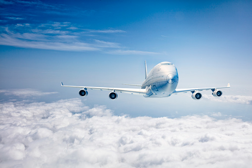 White passenger airplane flying over modern Izmir city