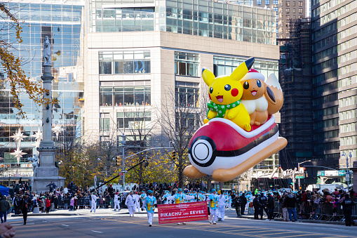 Wide angle view of the Pikachu and Eevee balloon flying in the Macy's Thanksgiving Day Parade 2023 in New York City.
