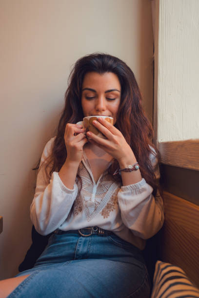 istock Relaxed woman drinking coffee in a restaurant while she is looking out the window 1811664761