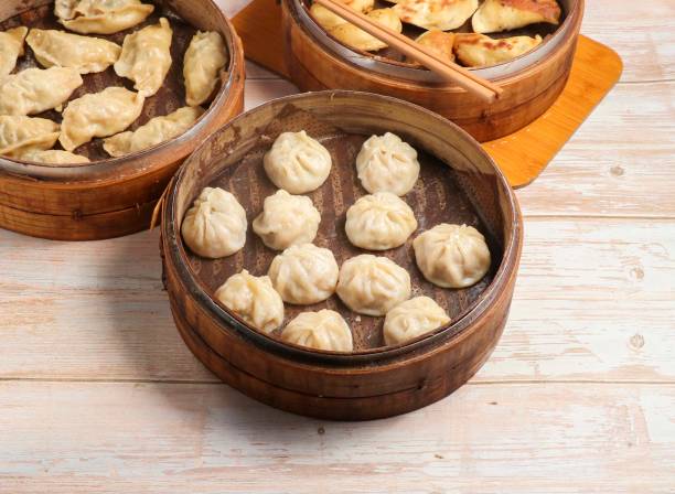 istock Handmade steamed dumplings and fried dumpling or momo served in wooden dish isolated on table top view Japanese food 1811668384