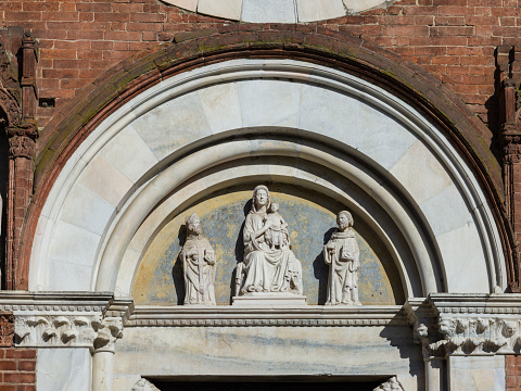 Viboldone, Lombardy, Italy - November 15, 2023: Abbey of Saints Peter and Paul. Lunette above the church door.