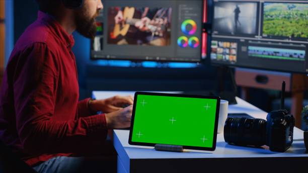istock Green screen tablet on desk in multimedia agency next to video editor working for production company 1811699406