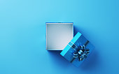 Open Gift Box Hollow White Color with Blue Ribbon and Blue Pattern Sitting on Light Blue Soft Floor Background