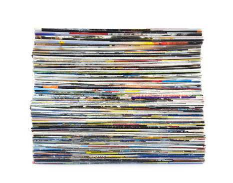 Stack of colorful magazines on white background