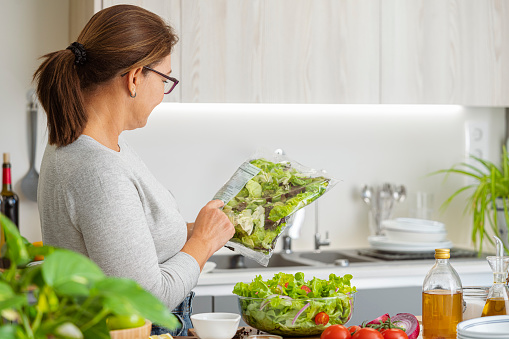 Woman reading nutrition label of a plastic packaged salad