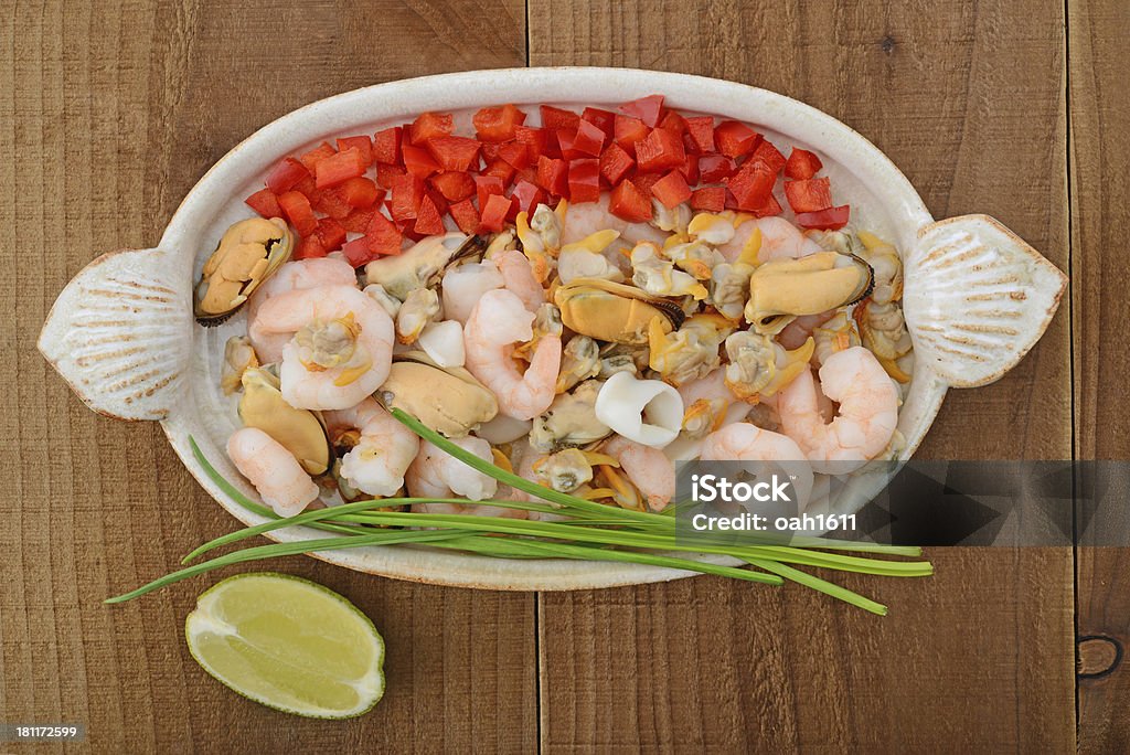 Seafood selection on ceramic plate Seafood selection: squid, king prawns, mussels and cockles with red pepper, spring onions and lime Appetizer Stock Photo