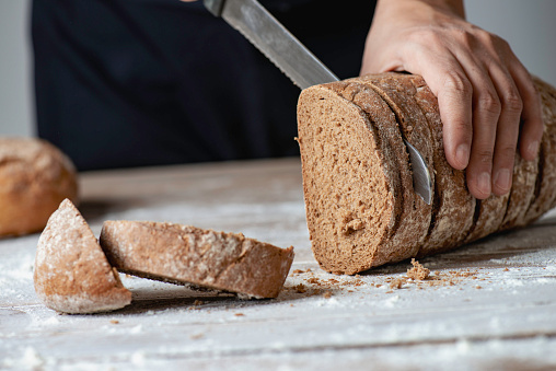 A woman cutting freshly made bread.