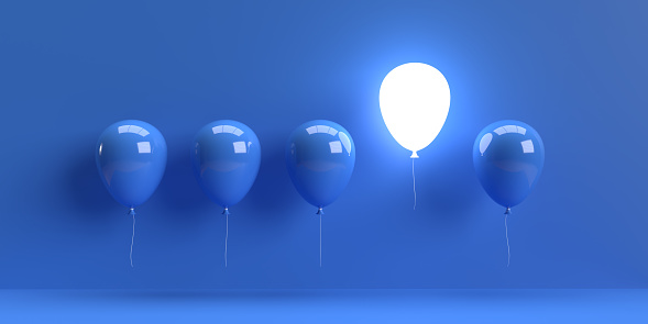 Leadership and teamwork concept. A single glowing white balloon stands out from the rest blue balloons as a symbol of leadership. 3D rendered objects with large copy space.