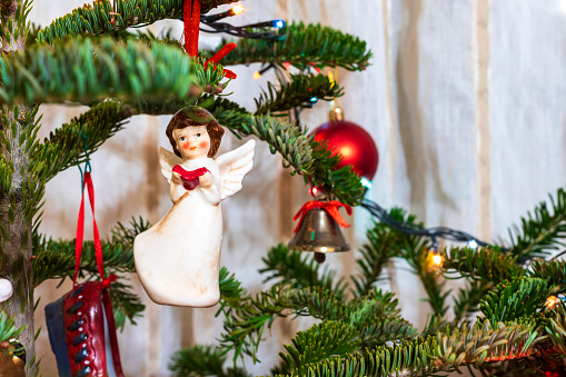 Beautiful little angel and balls on the Christmas tree. Festive decoration