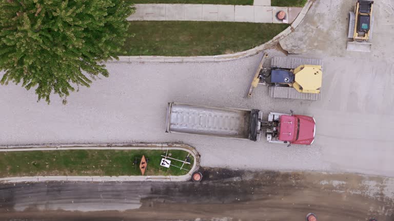 Aerial shot over of road construction process in suburbs. Top down drone view