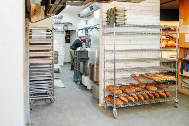 istock Busy Baker at Work in Commercial Bakery Kitchen with Fresh Bread 1811754684
