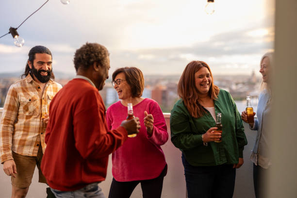 istock happy friends at a rooftop party drinking beer and having fun, multigenerational diverse multiracial family 1811761593