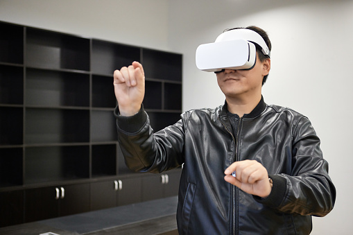 Shot of a middle-aged businessman using a virtual reality headset in a modern office