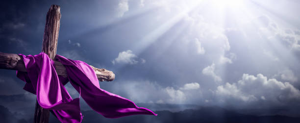 Flowing Purple Robe On Wooden Cross With Light From Heaven Shining Through The Clouds - The Resurrection And Ascension Of Jesus Christ