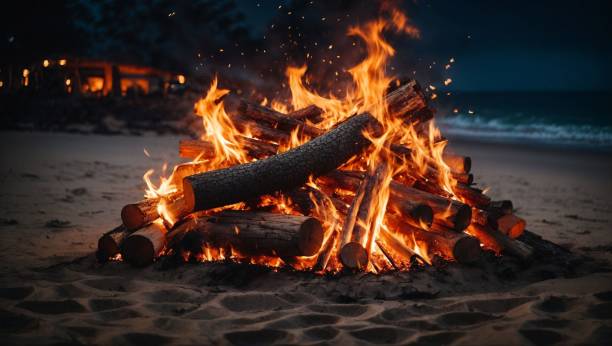 istock Isolated nighttime beach scene featuring a glowing fire pit surrounded by sand 1811834372