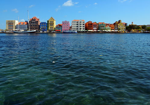 Willemstad, Curaçao, Kingdom of the Netherlands: Punda (Dutch: De Punt) is the oldest district of Willemstad  the capital of Curaçao . The district was originally called De Punt, which was translated into Papiamento as Punta and later corrupted to Punda. Punda is located east of Sint Anna Bay, and together with Otrobanda ('De Overkant'), located west of Sint Anna Bay, it forms the historic city center of Willemstad. The district is the main shopping area of ​​Willemstad and also has several museums. Punda has been connected to Otrobanda via a wooden pontoon bridge (Queen Emma Bridge) since 1886 and also via the Queen Juliana Bridge since 1974. Punda and Otrobanda have been on the UNESCO World Heritage List since 1997.