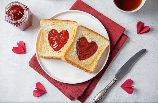 Sweet sandwiches with strawberry jam with heart shape inside for Valentine's day holiday. toning
