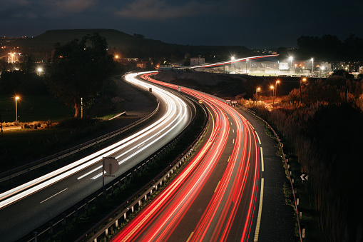 A highway at night with light trails in motion from traffic