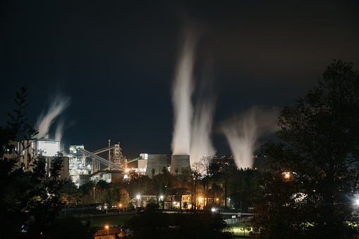 A large factory at night with smoke