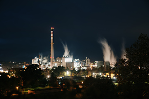 A large factory at night with smoke