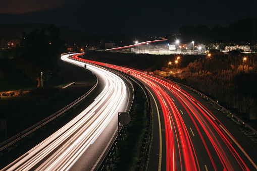 A highway at night with light trails in motion from traffic
