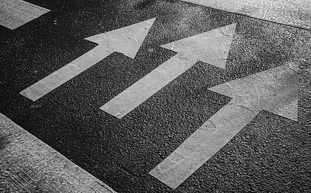 istock Pedestrian crossing road marking with white arrows on asphalt 181187759