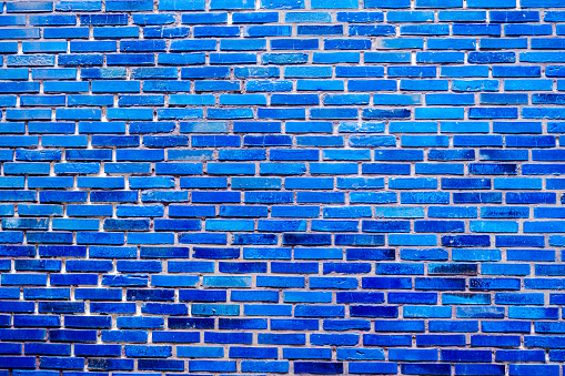 A bright blue painted brick wall, a background for cheerful masonry designs