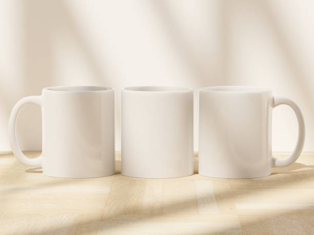 istock Three ceramic mugs sitting on a wooden floor with soft window shadows 1811913664