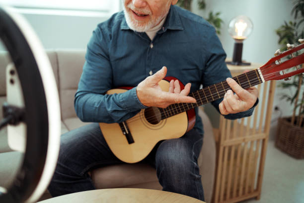istock Senior man vlogging about guitar from home 1811918124