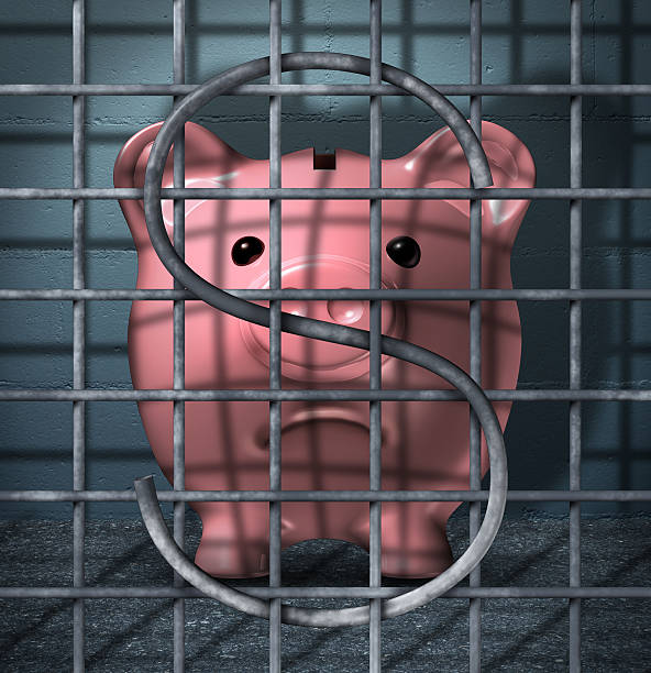 Financial Crime Financial crime and securities fraud business concept with a piggy bank character in a prison jail cell with a dollar sign symbol in the metal cage bars as an icon of justice for criminal finance activity. ponzi scheme stock pictures, royalty-free photos & images